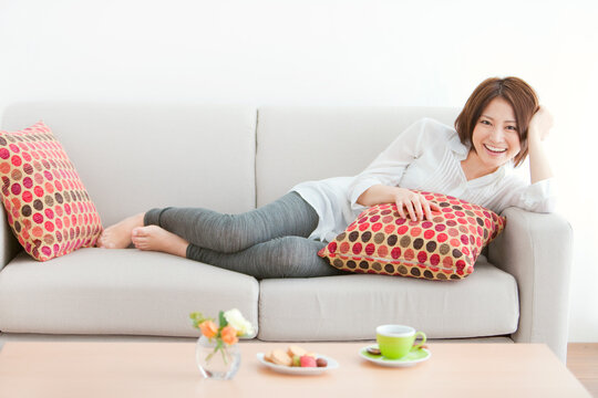 ソファーでくつろぐ笑顔の女性