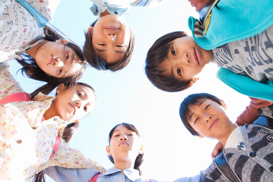 ランドセルを背負って輪になる小学生6人