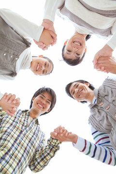 手をつないで輪になる笑顔の家族4人