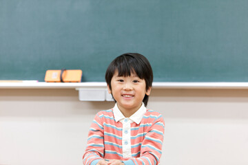 教室で笑顔の小学生の男の子