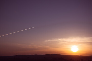 Sunset and streak from a flying plane.