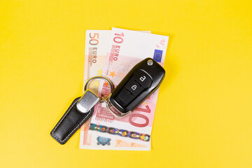 Car keys and money (euros). Selling, buying and renting a car.
