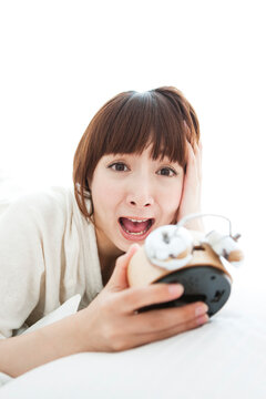 目覚まし時計を持つ女性