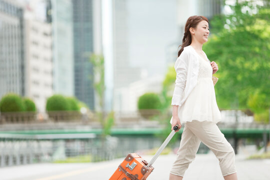 旅行かばんを持つ女性