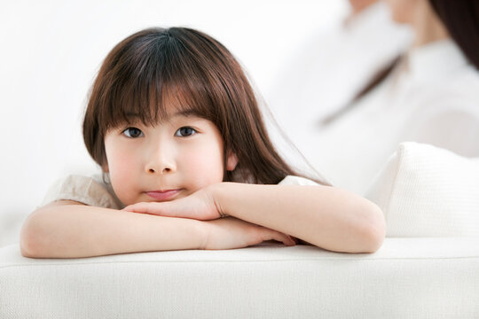 ソファに座る女の子と両親