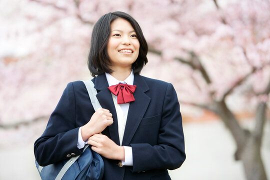 桜の木の下に立つ女子学生