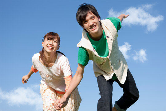手をつないで走る若いカップル