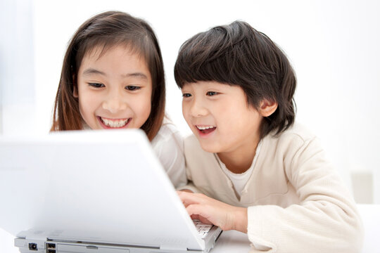 ノートパソコンを操作している子供2人