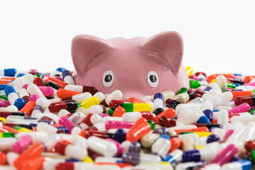 Pharma piggy bank drowning in a ocean of pills and capsules.