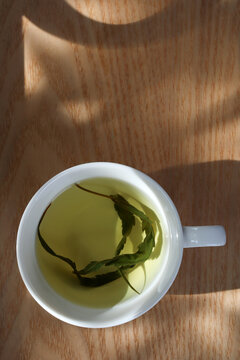 Top view hemp tea in a white cup with cannabis leaf