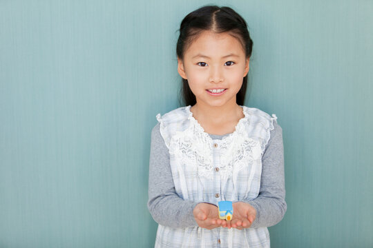 ミニチュアの家を持つ女の子