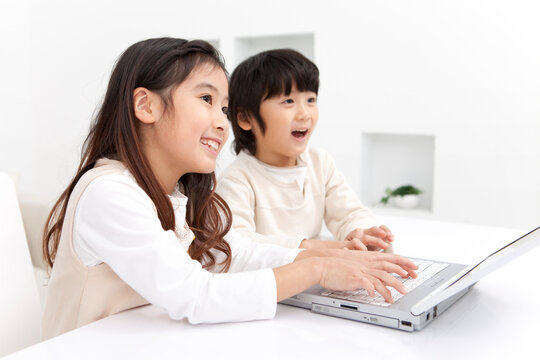 ノートパソコンを操作している子供2人