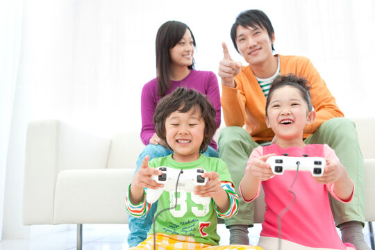 テレビゲームをしている家族4人