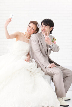 携帯で写真を撮る新郎新婦
