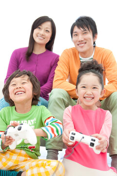 テレビゲームをしている家族4人