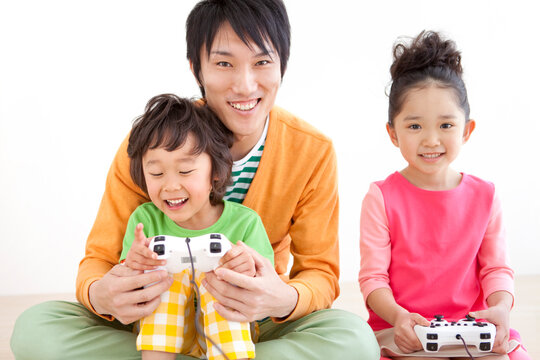 テレビゲームをしている家族3人