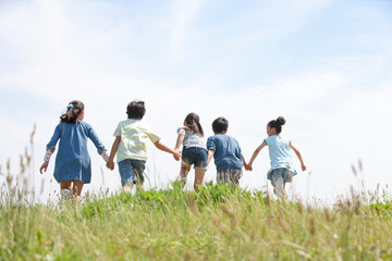 手をつないで走っている子供5人
