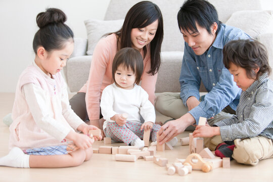 おもちゃで遊ぶ家族5人