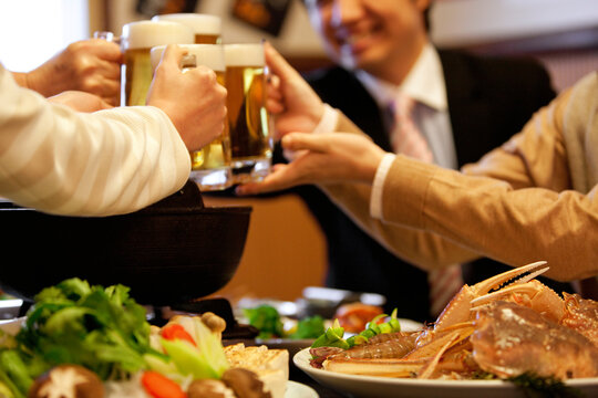 ビールで乾杯しているビジネスマン4人
