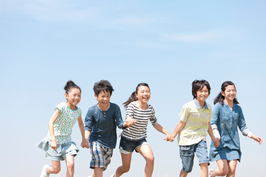手をつないで走っている子供5人