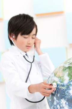 地球に聴診器をあてる男の子