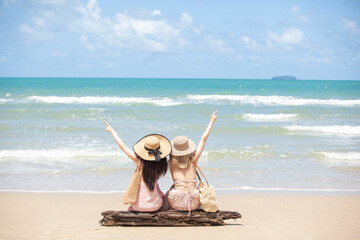 young women Asian and friends enjoying on the beach on a sunny day. Two young women Asian walking together on a beach. young women happy friends at sunset beach party runs to water