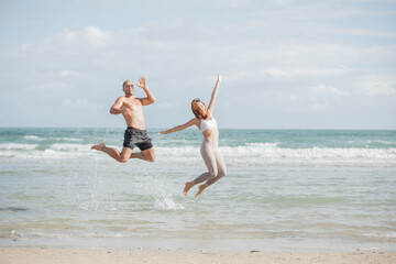 young couple walking at each other at beach. Romantic couple walking on sea, enjoying life and each other at honeymoon vacation.