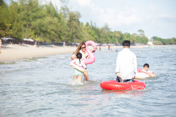 Happy young family Asian running on the beach with copy space. family enjoying