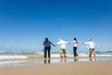 Asian Family Having Fun On Beach. Senior Woman On Holiday On Beach. family holiday and travel summer beach concept