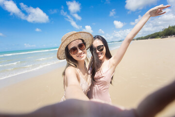 Fototapeta premium Beautiful young woman doing selfie on the beach. Relax travel on the beach concept