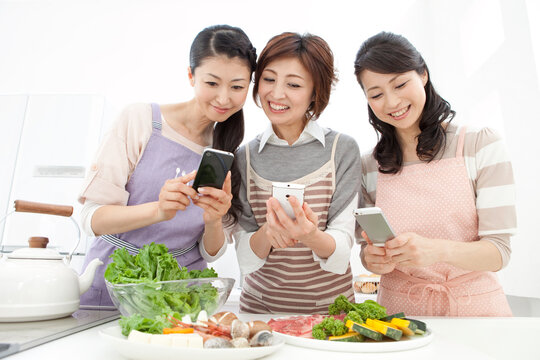 食材の写真を撮る中高年女性3人