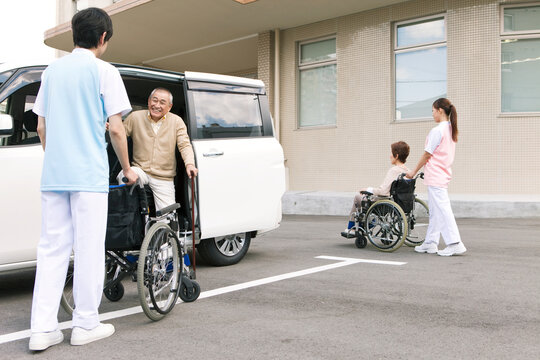 車から降りる杖をつく中高年男性