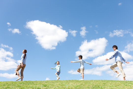 笑顔で歩いている家族4人