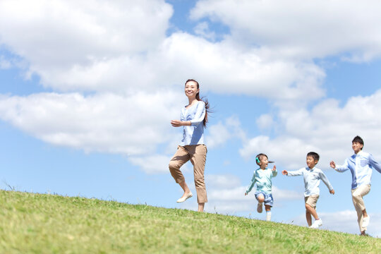 笑顔で歩いている家族4人