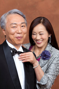 蝶ネクタイを整えている中高年夫婦