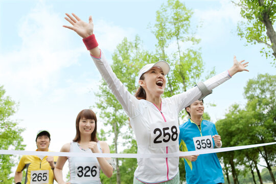 ゴールテープを切る女性