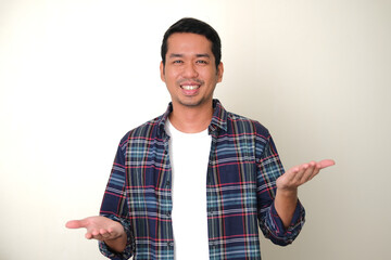 Adult Asian man showing not balance gesture with his hand