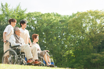 車いすを押す介護士と車いすに座る老人