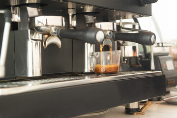 Large coffee machine and black mug while making coffee. Small business concept.