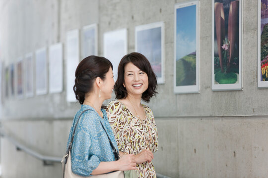 写真の前で話す中高年女性2人