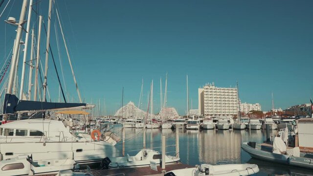 Parked Grande Mottes Yacht rocking on water and buildings on a beautiful day