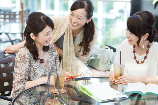 カフェで話す中高年女性3人