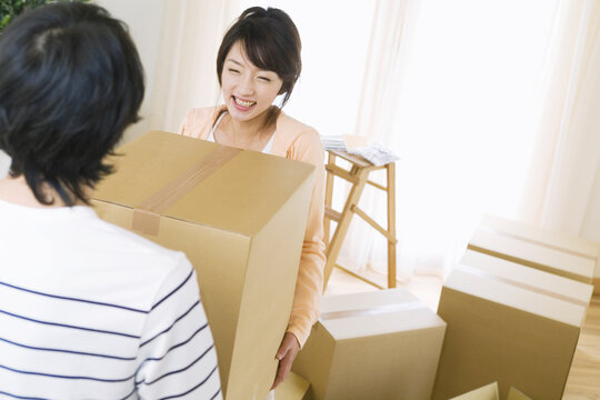 ダンボール箱を運ぶ若夫婦