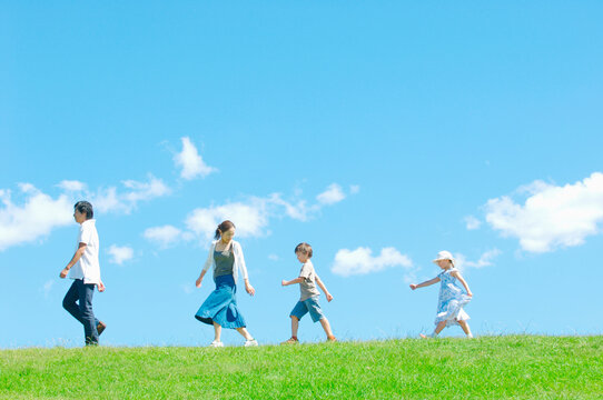 芝生を歩く4人家族