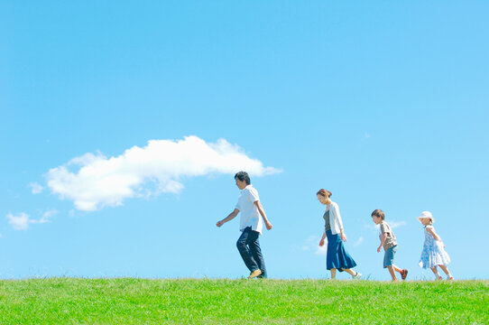 芝生を歩く4人家族