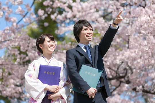 卒業証書を持つ大学生2人