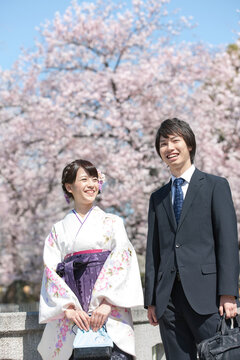 桜と笑顔の大学生2人