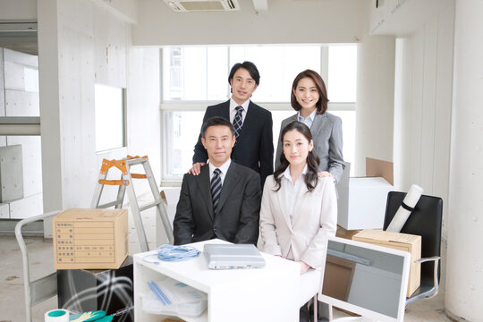 荷物に囲まれたビジネスマンとビジネスウーマン4人