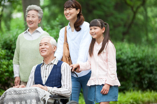 車椅子に乗るシニア男性と家族