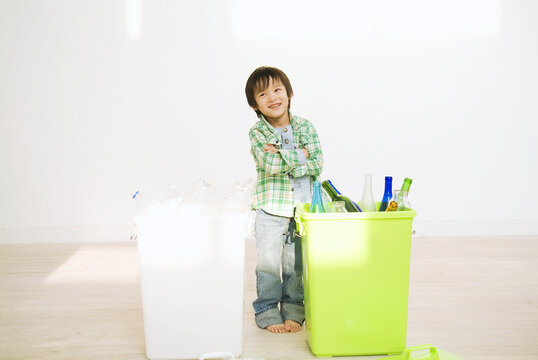 2つのゴミ箱の前で考える男の子
